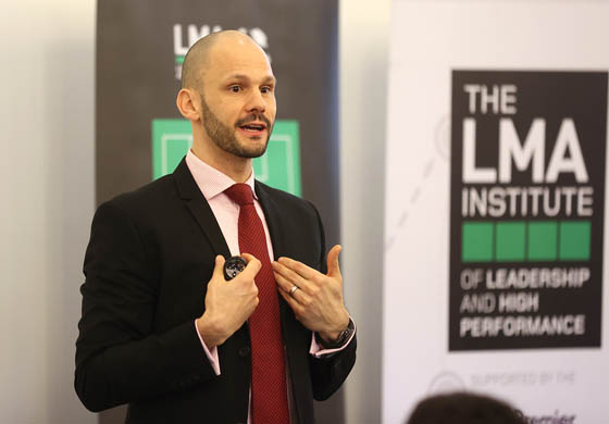 Dr. Marc Bubbs giving a presentation in front of a large group